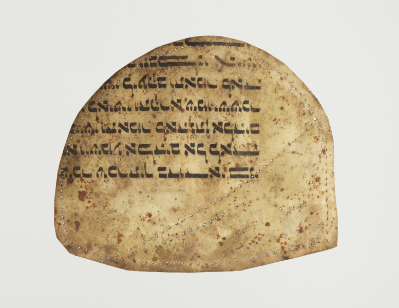 wzornik szewski - Wzornik szewski wykonany z fragmentu zwoju Tory. Kształt obiektu jest półokrągły z jednej strony (zbliżony do kształtu podkowy) i prosty z drugiej. Widoczne fragmenty tekstu w j. hebrajskim oraz liczne niewielkie otwory wzdłuż krawędzi oraz biegnące skośnie na 1/3 wysokości. Tekst skoncentrowany jest po jednej stronie (bliżej zaokrąglonej krawędzi). Na odwrocie zapisane długopisem ,,P. Górna’’ (?).