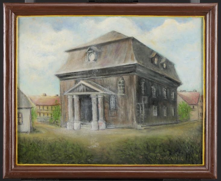 Widok na duży drewniany budynek (synagogę w Kórniku) w wiosennym pejzażu. Budynek z wysokim, mansardowym dachem i kolumnowym portykiem. Budynek piętrowy, w dachu trzy lukarny. W fasadzie trzy okna (jedno częściowo zakryte przez portyk), w bocznej elewacji (z prawej strony) potrójny rząd okien na dole i na górze. Tuż przy krawędzi budynku niewielkie, boczne wejście, po schodkach. Wysunięty do przodu portyk, zwieńczony trójkątnym frontonem, z dwoma kolumnami po każdej stronie, osłania główne wejście do budynku.
W głębi, po obu  stronach budynku znajdują się niskie domy o spadzistych dachach, z kominami, krytych czerwoną dachówką. Są otoczone drewnianymi płotami. Przy domach rosną drzewa (z obu stron drewnianego budynku) z niewielkimi koronami w kolorze jasnej zieleni. Na pierwszym planie pas ciemnej zieleni, trawy i niskich krzewów. Niebo jasnoniebieskie, z białymi chmurami. Obrysy budynków, kominy, drzewa nakreślone cienko czarną farbą.
Obraz w ramie.