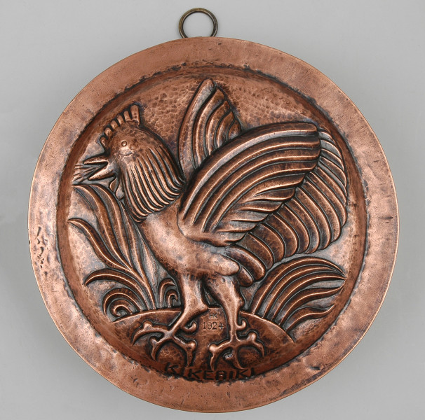 ujęcie z góry. Na wierzchu naczynia wytłoczony piejący kogut z rozpostartymi skrzydłami.