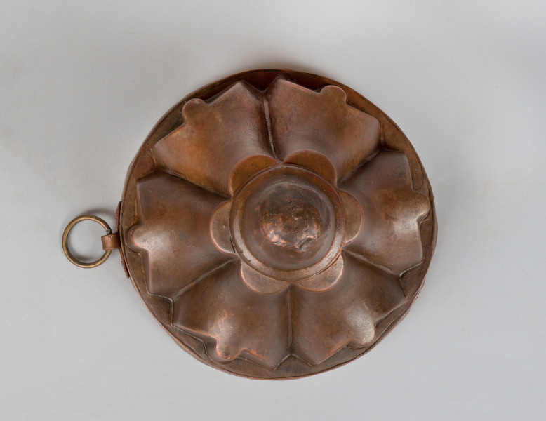 ujęcie z góry. Ukształtowanie powierzchni naczynia tworzy jakby sześciopłatkowy kwiat, którego środek stanowi kula na szczycie.