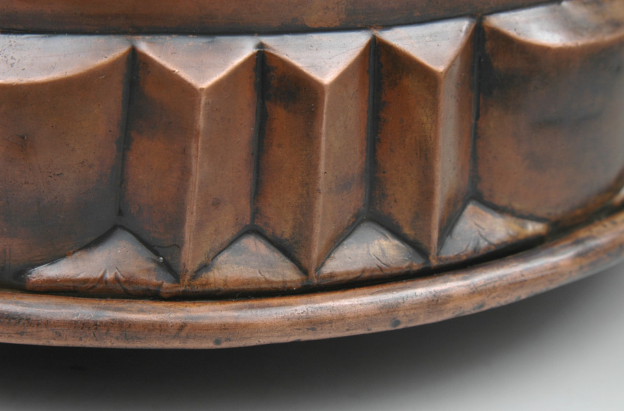 zbliżenie na dolny pas dekoracji. Powtarzający się detal trzech ostrosłupów rozdzielonych półwałkiem. Ujęcie z zewnątrz.