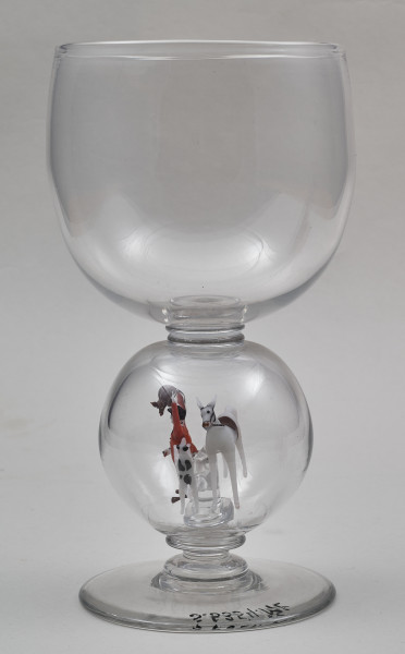 Kielich w typie „Römer”. Posiada półkolistą czaszę z cylindrycznym zwężeniem u góry. Charakterystyczny jest nodus w kształcie kuli. Kielich zakończony jest okrągłą, gładką stopą. Stopa i czara połączone są z nodusem pierścieniami. W nodus wtopiona jest scena myśliwska.