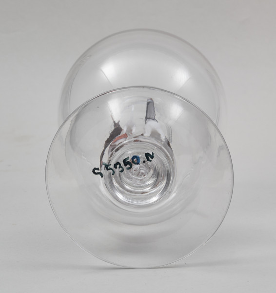 Kielich w typie „Römer”. Posiada półkolistą czaszę z cylindrycznym zwężeniem u góry. Charakterystyczny jest nodus w kształcie kuli. Kielich zakończony jest okrągłą, gładką stopą.