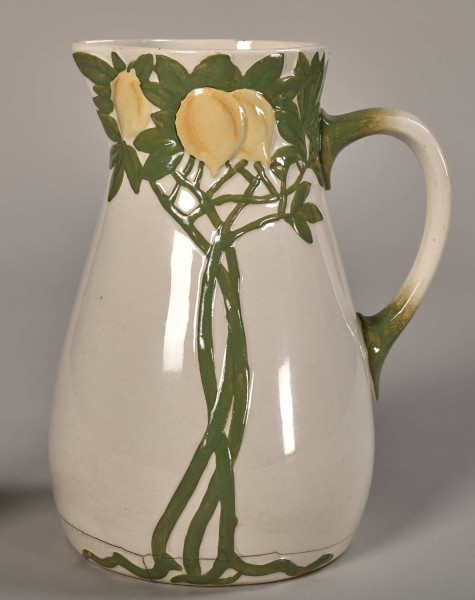 Dzbanek toaletowy, mały, zdobiony gałązkami i owocami cytryny. Widok na dekorację roślinną i uchwyt z prawej strony.