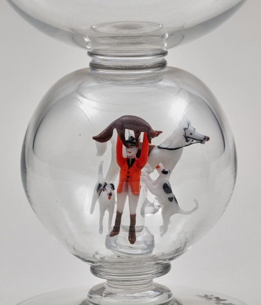 Kielich w typie „Römer”. Posiada półkolistą czaszę z cylindrycznym zwężeniem u góry. Charakterystyczny jest nodus w kształcie kuli. Kielich zakończony jest okrągłą, gładką stopą. Stopa i czara połączone są z nodusem pierścieniami. W nodus wtopiona jest scena myśliwska.