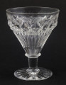 Kieliszek duży, wykonano ze szkła kryształowego
Stopa okrągła, nóżka krótka i szeroka, zakończona pierścieniem, na którym osadzona stożkowata czara. Spód stopy dekorowany płytkim szlifem o motywie wielopłatkowego kwiatka.
