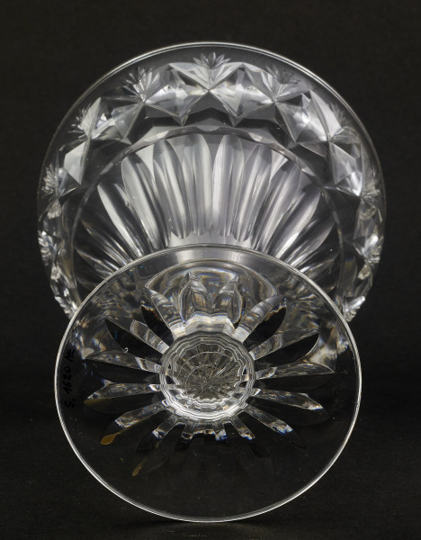 Stopa okrągła, nóżka krótka i szeroka, zakończona pierścieniem, na którym osadzona stożkowata czara. Spód stopy dekorowany płytkim szlifem o motywie wielopłatkowego kwiatka.