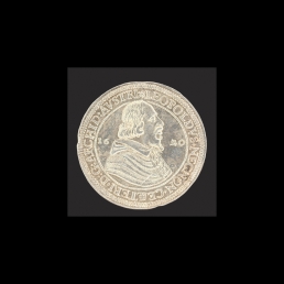 Moneta z popiersiem władcy w prawo dzielacym datę 16-20, napis w otoku. Na rewersie  sześciopolowa tarcza herbowa przykryta koroną arcyksiążęcą, poniżej małe tarcze herbowe biskupstw Pasawy i Strasburga, napis w otoku.